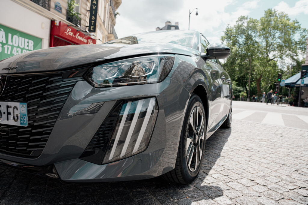Gros plan sur une voiture d’auto-école La Navette, garée en ville par temps ensoleillé.